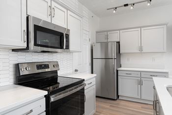 A kitchen with white cabinets and stainless steel appliances